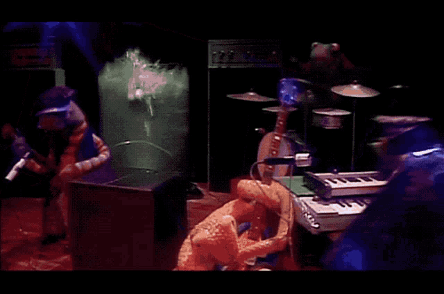 a group of stuffed animals are playing instruments in a dark room with a sign that says ' a ' on it