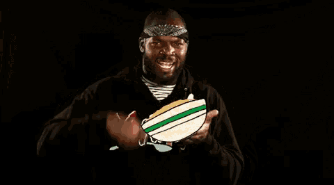 a man wearing a bandana is eating a bowl of cereal with a spoon