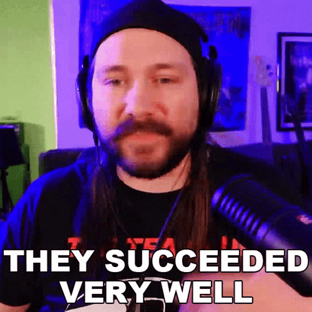 a man with long hair and a beard is wearing headphones and a hat and says they succeeded very well