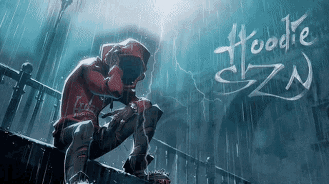 a man in a red hoodie is sitting on a railing in the rain