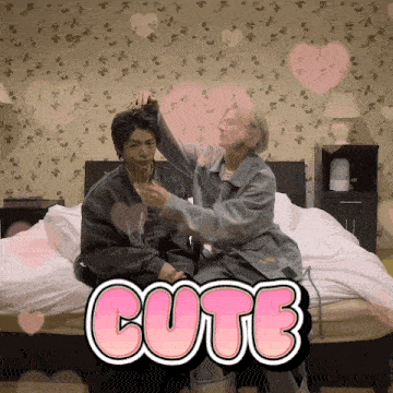 a couple sitting on a bed with the word cute on the bottom right