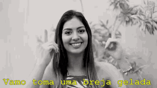 a woman is smiling in a black and white photo with the words vamos toma uma breja gelada written in yellow .