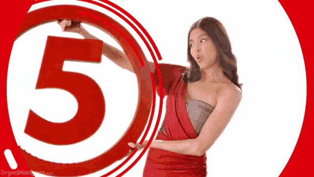 a woman in a red dress is holding a large red 5
