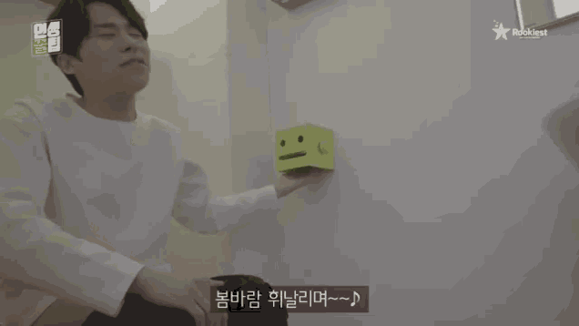 a man is holding a yellow box with a face on it