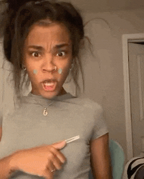 a woman is making a funny face while holding a razor .