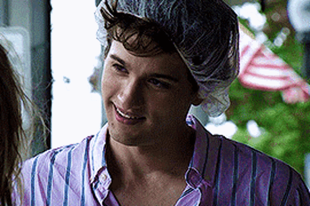 a man wearing a shower cap is smiling and looking at the camera