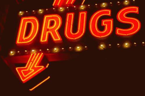 a neon sign that says " drugs " with an arrow pointing to the right