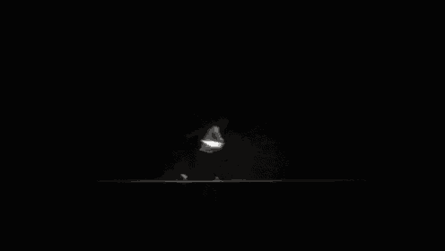 a black and white photo of a person standing in the dark .