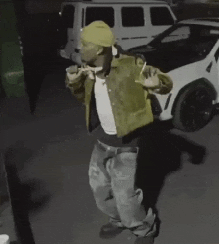 a man in a green jacket is standing in front of a white van