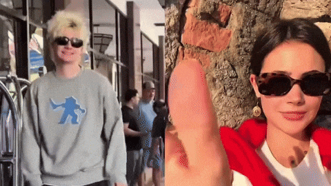 a man and a woman wearing sunglasses are standing next to each other on a sidewalk