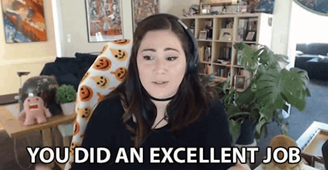 a woman wearing headphones is sitting in a living room and says you did an excellent job .