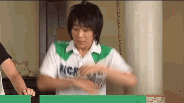 a man wearing a green and white shirt with the word high on it .