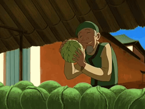 a man is holding a cabbage in his hands and smiling