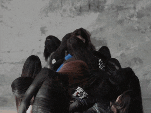 a group of women are huddled together with one wearing a shirt that says ' i am here ' on it