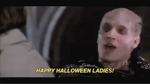 a man with a bald head is talking to a woman and saying `` happy halloween ladies '' .