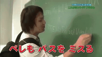 a man is writing on a blackboard with chinese writing