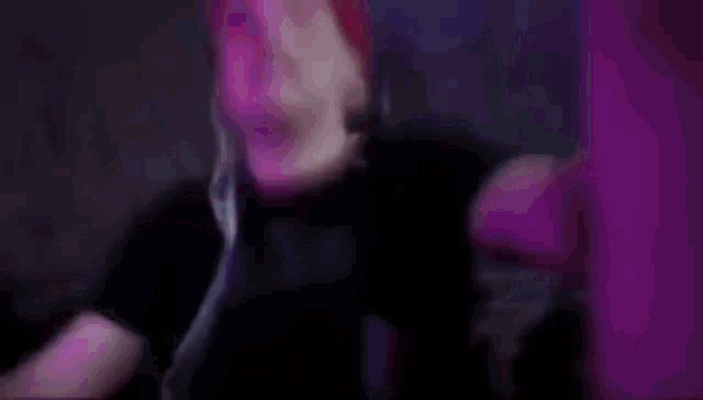 a close up of a person 's face with pink hair covering their face .