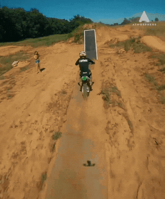 a person on a dirt bike going down a ramp with the atmosphere logo in the corner