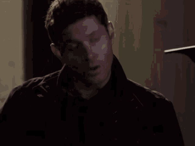 a man with his eyes closed is wearing a black jacket and black shirt