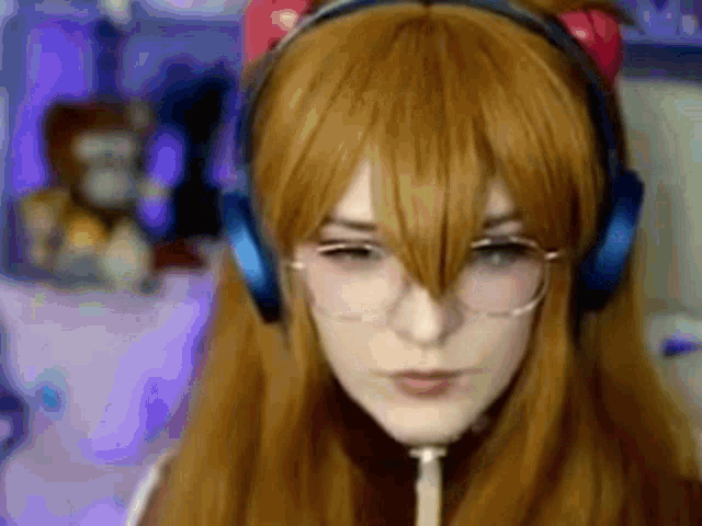 a woman wearing headphones and a wig is sitting in front of a computer .