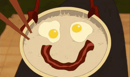 a bowl of rice with eggs and bacon making a face