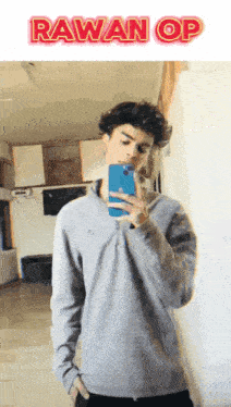 a young man taking a selfie in front of a sign that says ' rawan op '