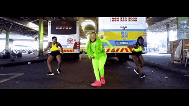 a woman in neon green is dancing in front of a man metro bus