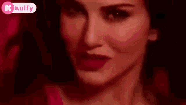 a close up of a woman 's face with a red background