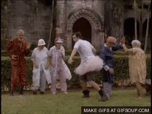 a group of elderly people are dancing in a park .