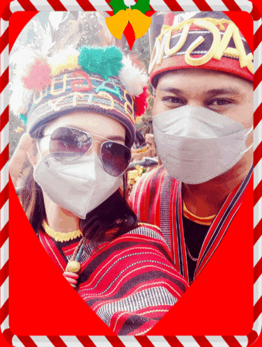 a man and a woman wearing face masks are posing for a picture in a heart shaped frame