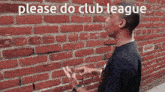 a man is standing in front of a brick wall with the words please do club league written on it