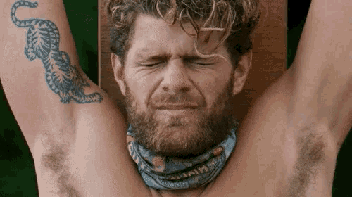 a man with a tattoo of a tiger on his arm has his eyes closed