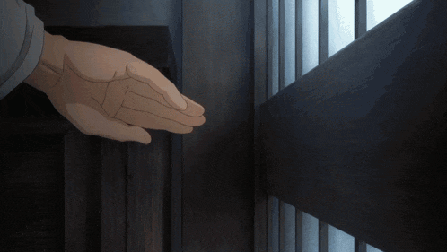 a person 's hand is reaching out towards a wooden door