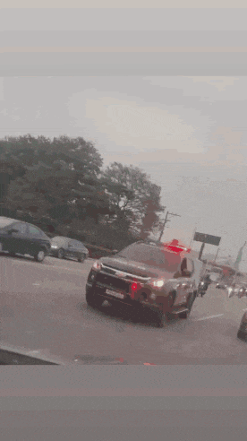 a police car is driving down the highway with a blue light on the top