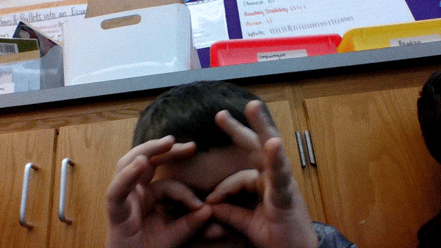 a person covering their face with their hands in front of a shelf with a sign that says " another disability " on it