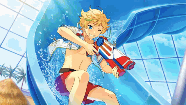 a boy is holding a water gun while riding a water slide
