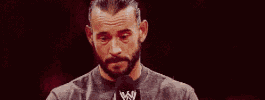 a man with a beard is speaking into a microphone .