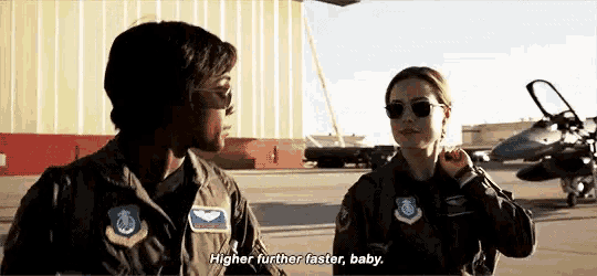 two women in military uniforms are standing next to each other on a runway .