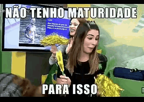 a woman holding a yellow pom pom in front of a tv screen that says " não tenho maturidade para isso "