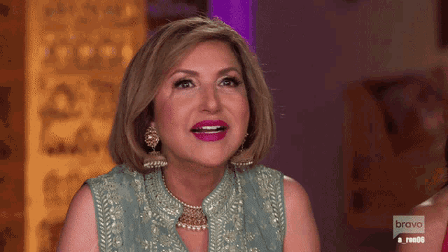 a woman is smiling in front of a bravo logo