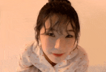 a close up of a young woman 's face with a bun .