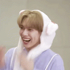 a young man wearing a bunny hat is covering his face with his hands .