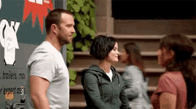 a man and a woman are standing next to each other and talking to each other .