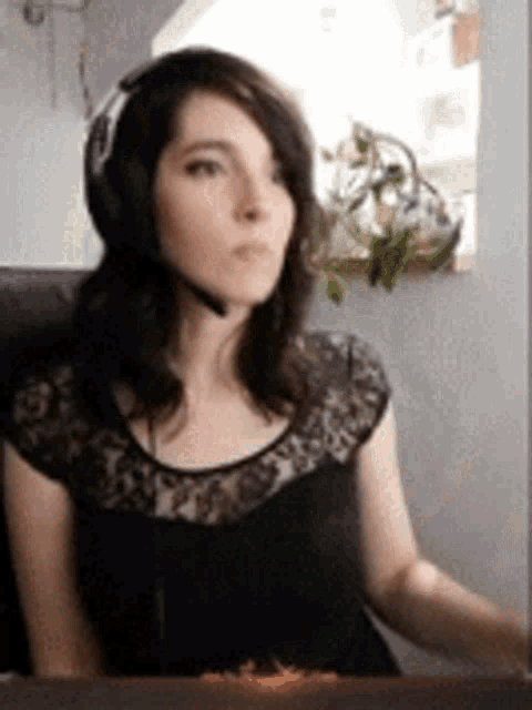 a woman wearing headphones and a black lace top