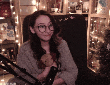 a woman sitting in a chair holding a stuffed animal with the number 3751 rub on the bottom