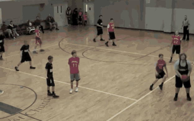 a basketball game is being played in front of a sign that says st. church