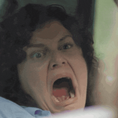 a close up of a woman 's face with her mouth wide open