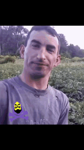 a man wearing a purple shirt with a yellow skull and crossbones