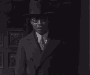 a black and white photo of a man in a suit and hat