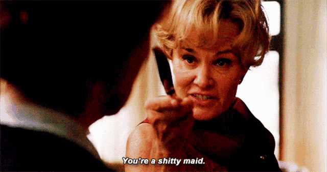 a woman is holding a knife in her hand and says you 're a shitty maid